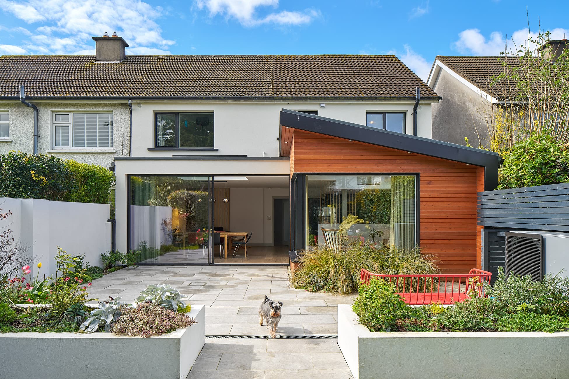 Single-storey rear extension with a timber-clad mono-pitch section and Sky-Frame sliding doors in Glenageary, Dublin, by Shomera